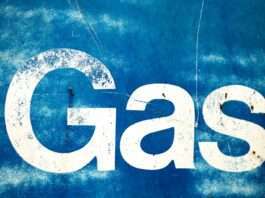 the word gas painted on the side of a blue wall